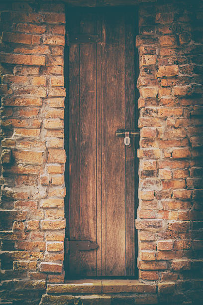istock Old wood door and brick wall 602303188