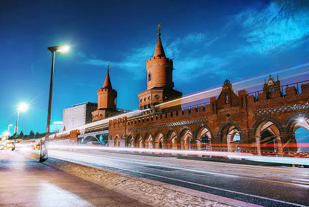 train and cars passing Oberbaumbrücke at blue hour