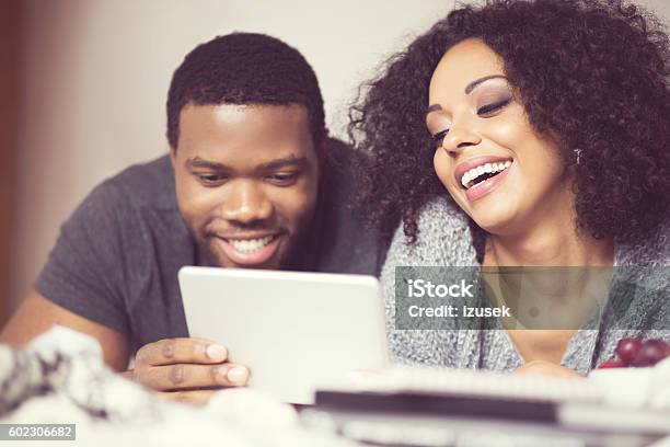 Afro American Couple Using A Digital Tablet Stock Photo - Download Image Now - Adult, Adults Only, African Ethnicity