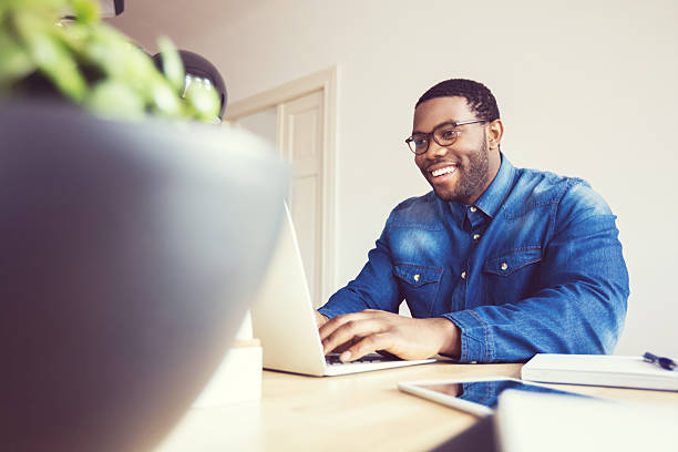 istock Afro american young man typing on laptop in an office 602306994