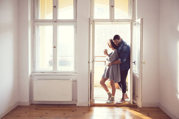 istock Afro american couple standing by the window at home 602308488