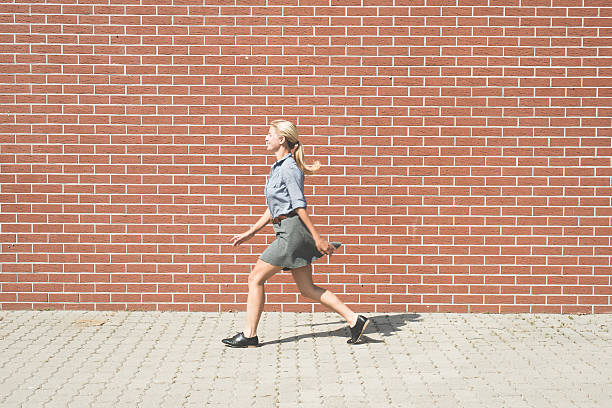 istock Young successful business woman walking against brick wall 602313502