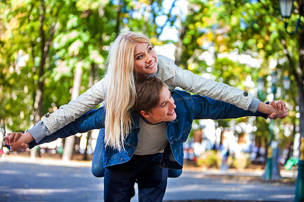 istock Young couple hugging and flirting in park. 602317004