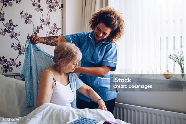 Home Caregiver Dressing Senior Stock Photo - Download Image Now - Home Caregiver, Nurse, Assisted Living