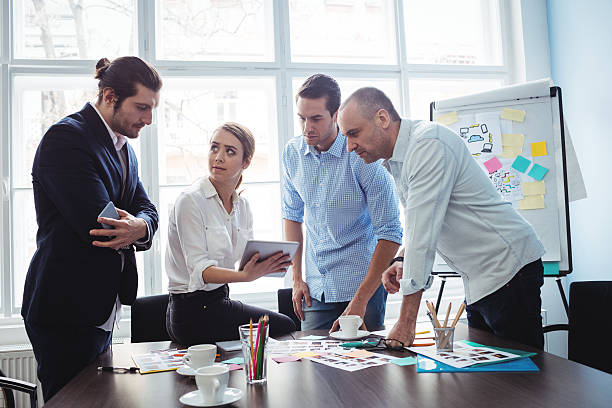 istock Editors with documents and digital tablet discussing in meeting room 602320346