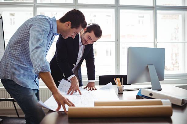 istock Interior designer discussing blueprint with colleague 602320408