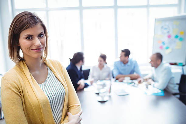istock Confident businesswoman standing against colleagues 602320470