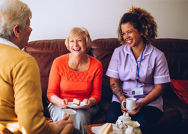 Caregiver Sharing Tea Time with her Patients stock photo