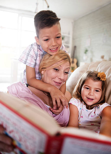istock mother with kids  reading a book at home 602322864