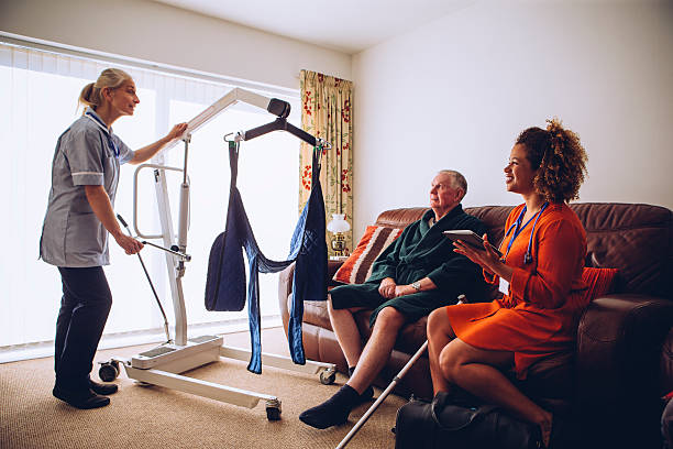 homecare workers preparing hoist - retrieving imagens e fotografias de stock