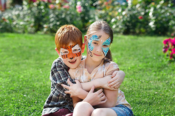 bambini felici, ragazzo e ragazza con vernice per il viso nel parco - face paint child animal little boys foto e immagini stock