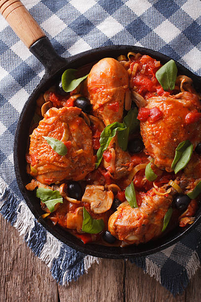 istock Cacciatori Chicken with black olives close-up in a pan. vertical 602324748