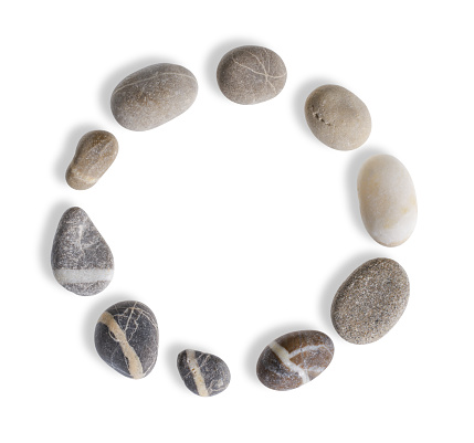 circular arrangement with small pebbles in white back with shadow seen from above