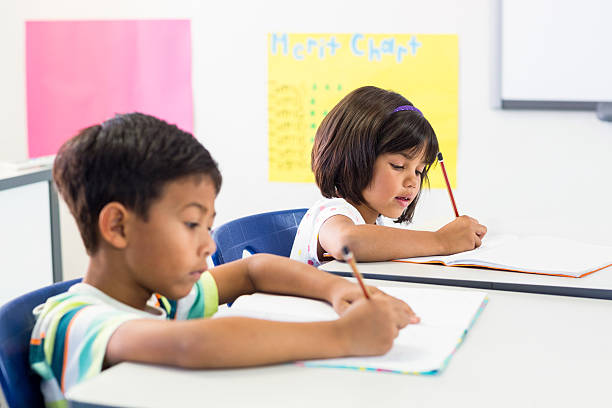 istock Schoolchildren writing on books 602326442