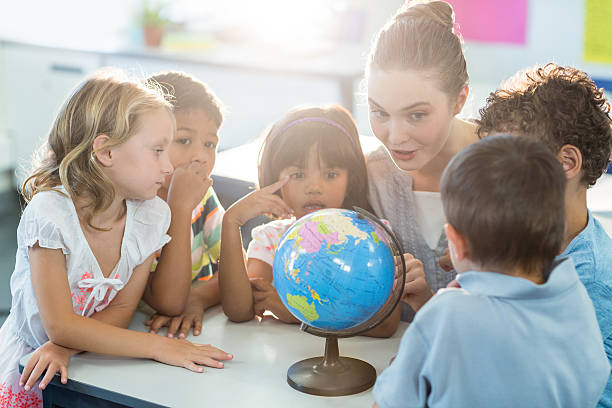 istock Teacher showing globe to schoolchildren 602326450