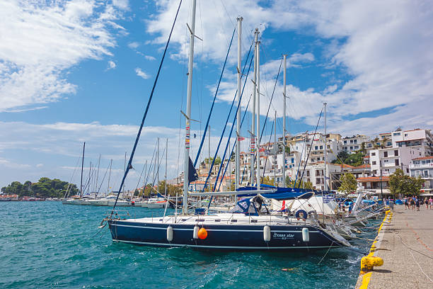 Skiathos, Greece - September 7, 2016: View of Skiathos town in a sunny day with boat in the harbor and people walking around. Greece