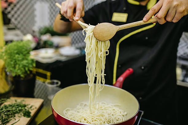 istock Chef holding spaghetti with two wooden spoons 602327700
