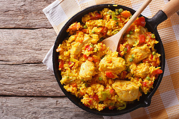 Hispanic cuisine: Arroz con pollo in pan. horizontal top view Hispanic cuisine: Arroz con pollo in a frying pan on the table. horizontal top view tomato rice stock pictures, royalty-free photos & images