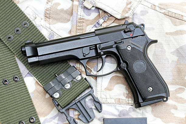 istock Gun on Military texture, 9mm pistol. 602329684
