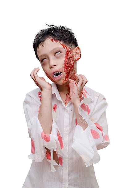 Young asian boy in zombie make up and costume over white