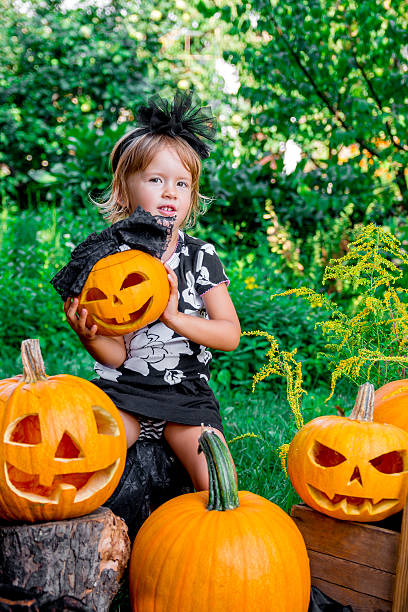 istock Halloween. Child dressed in black with jack-o-lantern 602330310