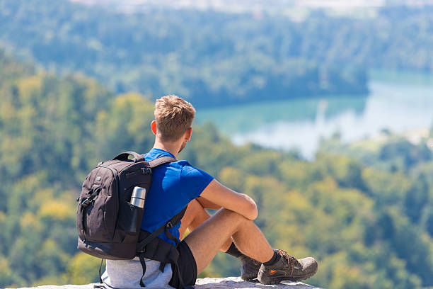 istock Happy hiker enjoy the view on mountain top rock 602330752