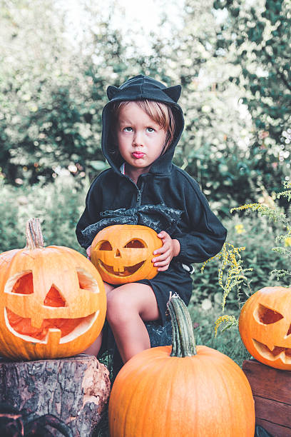 istock Halloween. Child dressed in black with jack-o-lantern 602331164