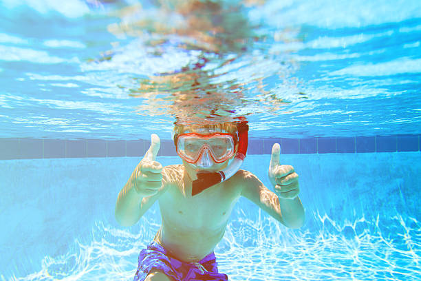 istock happy boy swimming underwater with thumbs up 602332534