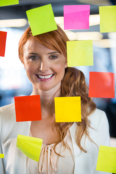 istock Businesswoman seen through glass with adhesive notes 602336172