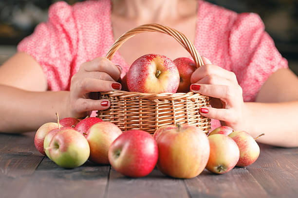istock Woman holding a white basket with red apples. 602337060