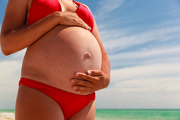 istock Happy pregnant woman at beach 602337574