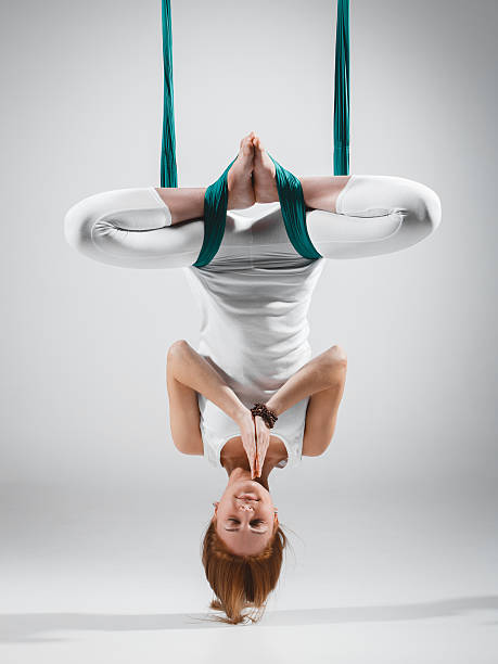 femme faisant de l’antigravité, de la mouche, des positions de yoga aérien dans le hamac - inversion yoga photos et images de collection