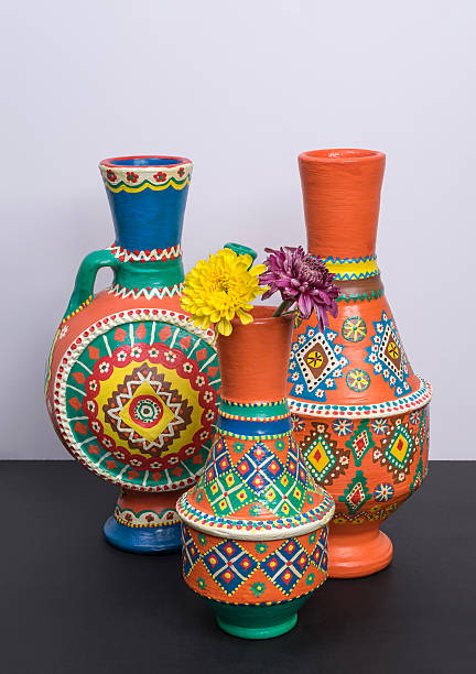 istock Three ornate pottery vases with two yellow and violet flower 603152636
