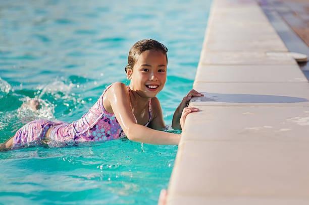 istock Child girl in blue swimming pool 603153404
