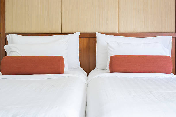 istock White bedding sheets and pillow in hotel room 603157408