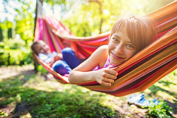 istock Little girl and her brother playing on hammock 603157968