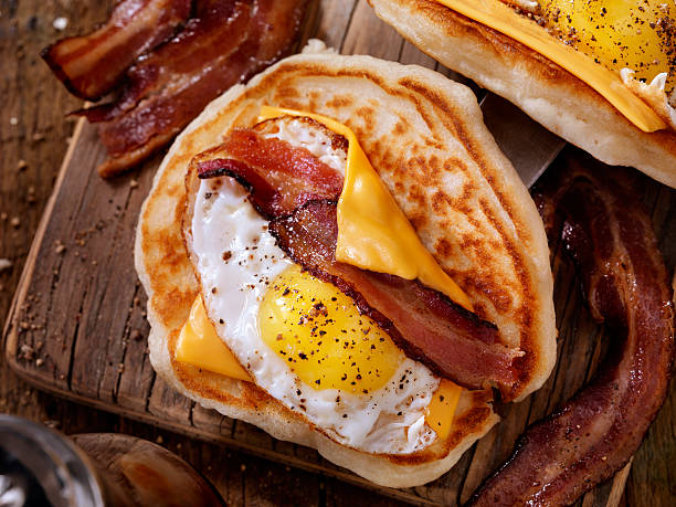パンケーキ朝食タコスとサニーサイドアップエッグ、ベーコン、チーズ - omelet breakfast eggs onion ストックフォトと画像