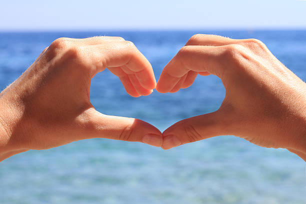 istock Woman making heart shape with her hands , enjoying summer holiday 603158278