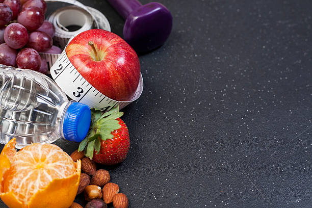 istock Fitness, exercise themed scene with dumbbells, water, fruit. 603158760