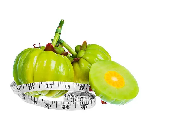 Photo of Garcinia cambogia fresh fruit with tapeline, isolated on white.