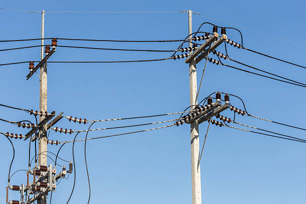 istock Electric pole connect high voltage electric wires on blue sky 603159954