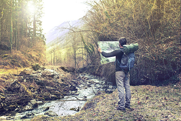 verlorener mann beobachtet karte, um den richtigen weg zu finden - backpacker green vacations outdoors stock-fotos und bilder