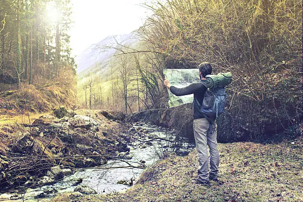 Photo of lost man observing map to find the the right way