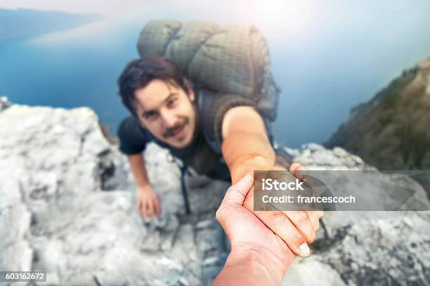 Adventurers Helping Each Other To Climb The Mountain Stock Photo - Download Image Now