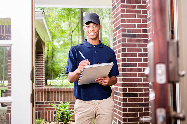 istock African descent repairman at customer's front door. 603163246