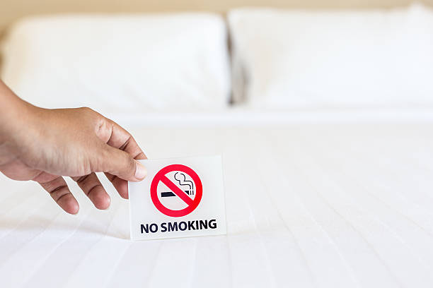 istock Hand holding NO SMOKING sign on the bed 603163648