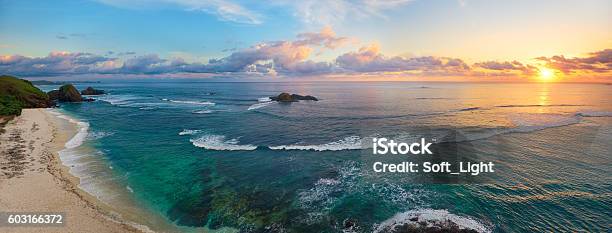 Panoramic View Of Tropical Beach With Surfers At Sunset Stock Photo - Download Image Now