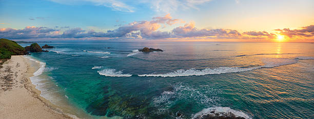 panoramic view of tropical beach with surfers at sunset. - kuta bildbanksfoton och bilder