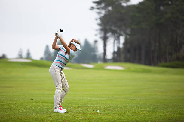 Perfect golf shot by a young female golfer stock photo