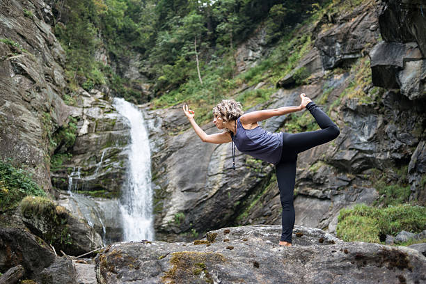 yoga-übungen in der natur: herr der tanzpose (natarajasana) - natural phenomenon waterfall rock tranquil scene stock-fotos und bilder